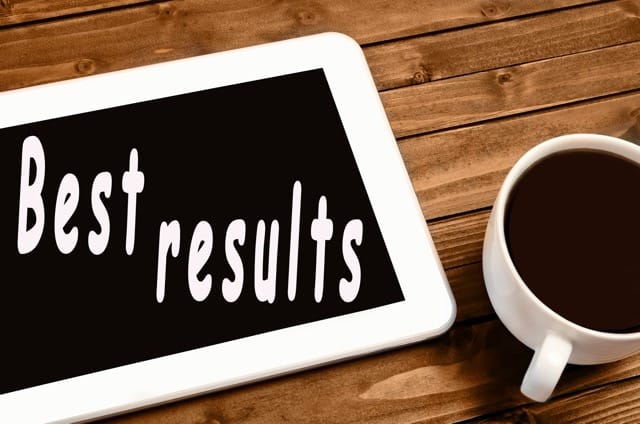 best results displayed on a tablet laying on a table next to a cup of coffee.